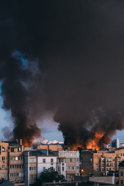 Free Thick black smoke rises over the cityscape of Kyiv, showcasing urban destruction. Stock Photo