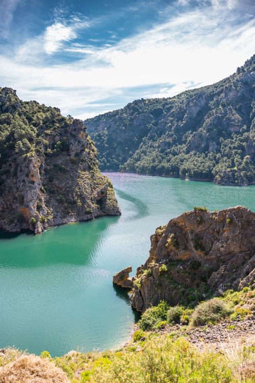 Free Stunning river view with lush mountains and clear skies in the background. Stock Photo