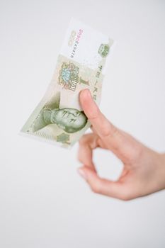 手持纸币的手部特写，象征金融和经济概念