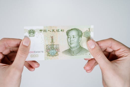 Close-up of hands holding a one Chinese Yuan note, showcasing currency details.