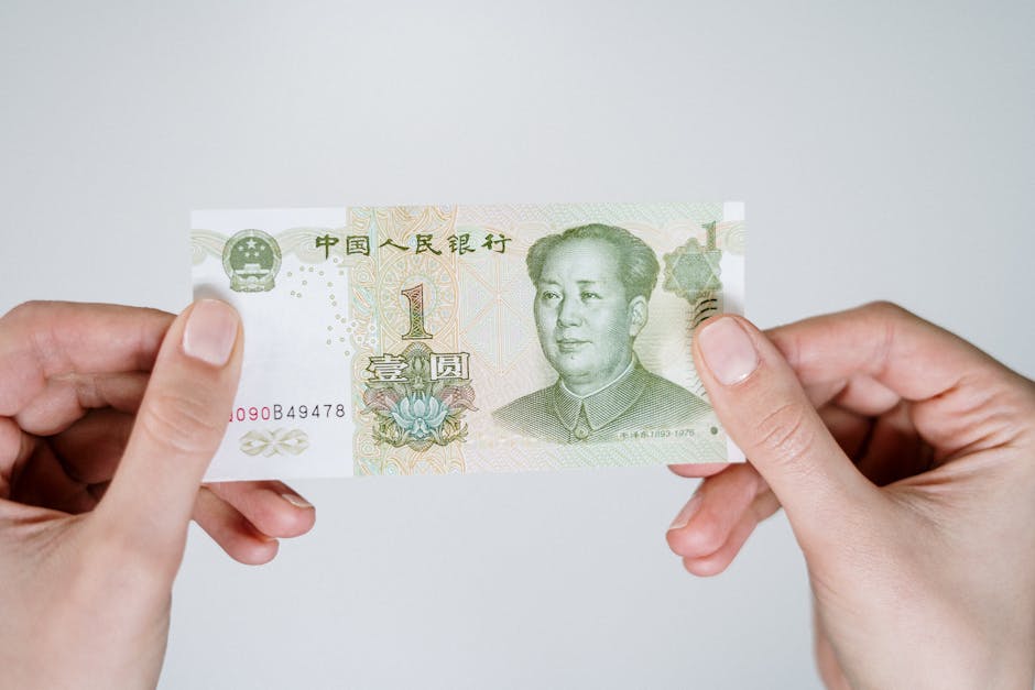 Close-up of hands holding a one Chinese Yuan note, showcasing currency details.
