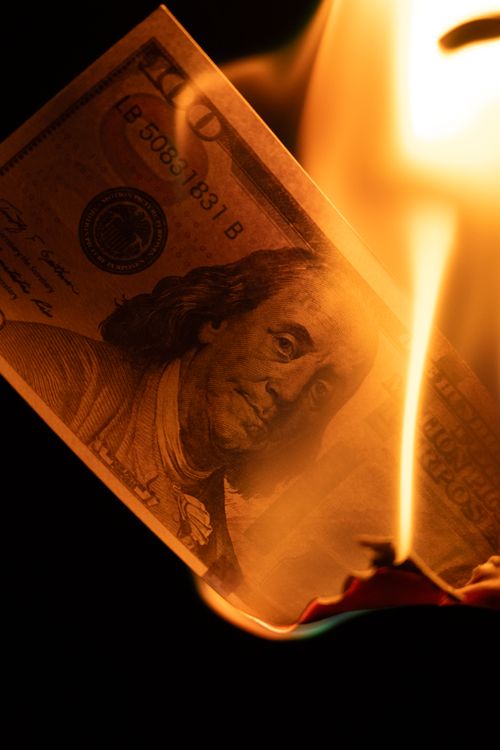 Free Close-up of a burning $100 bill symbolizing financial risk and economic crisis. Stock Photo
