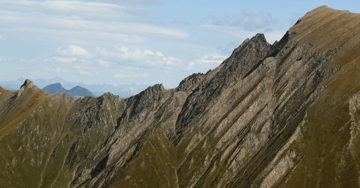 Breathtaking alpine mountain ridge under blue skies, showcasing impressive geology and beauty.