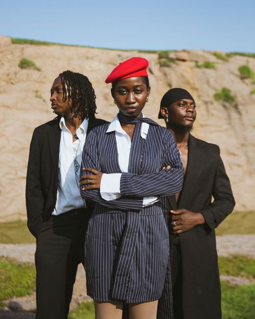 Free Three fashionable individuals pose confidently in an outdoor setting, showcasing unique styles. Stock Photo