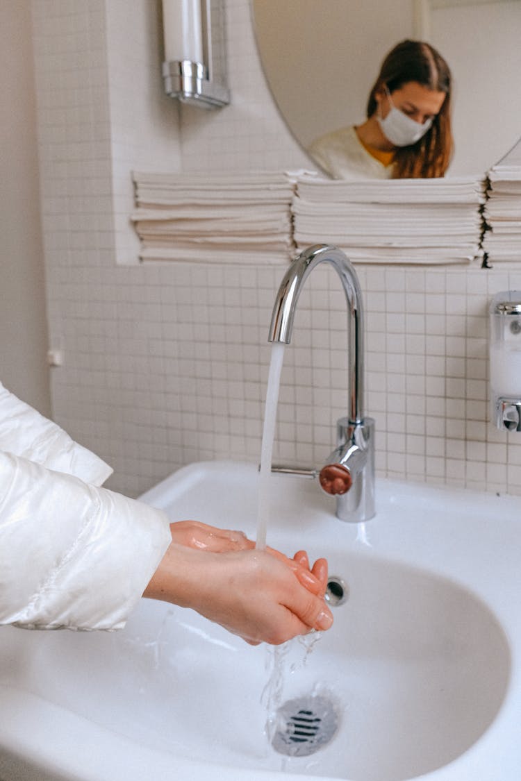 Woman With A Face Mask Washing Her Hands