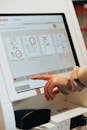 Person in Brown Long Sleeve Shirt Using Self Service Check in Kiosk