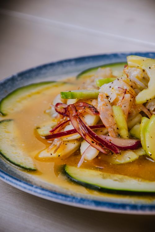 Free Colorful Asian shrimp salad with cucumber and red onions on a blue plate. Stock Photo