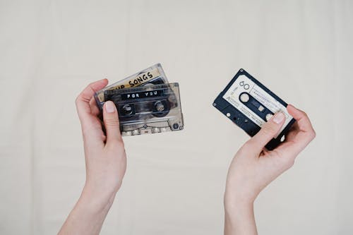 Person Holding Various Cassette Tapes