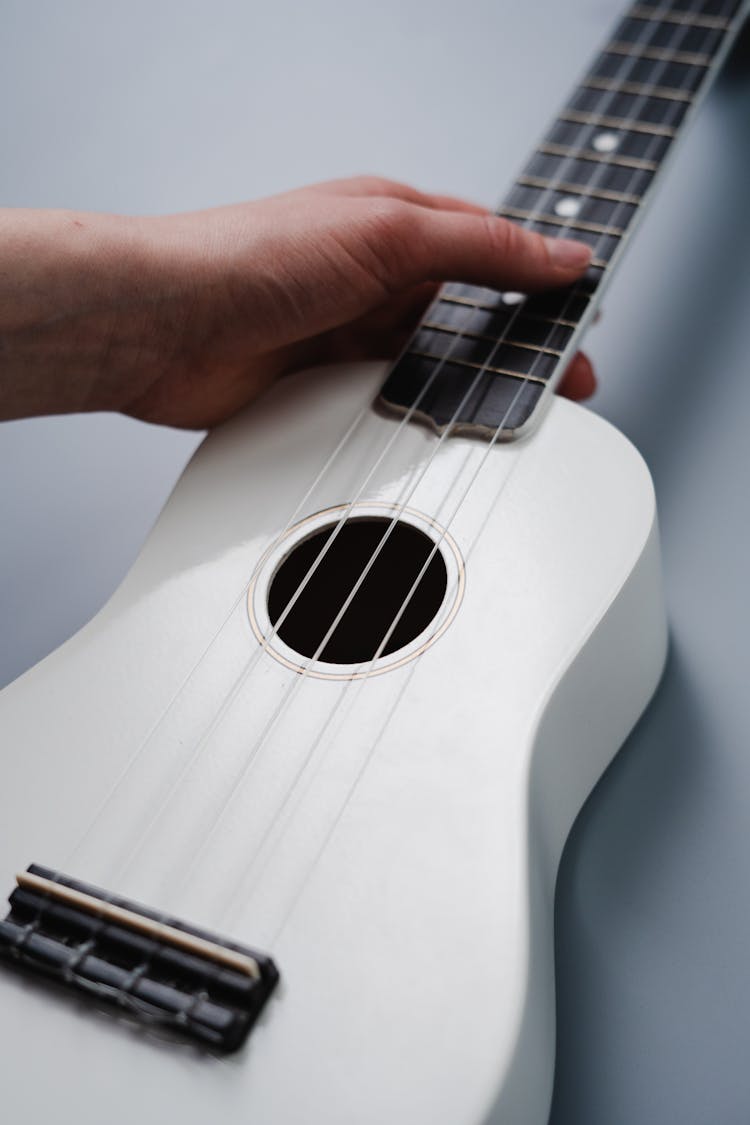 Person Holding White Acoustic Guitar