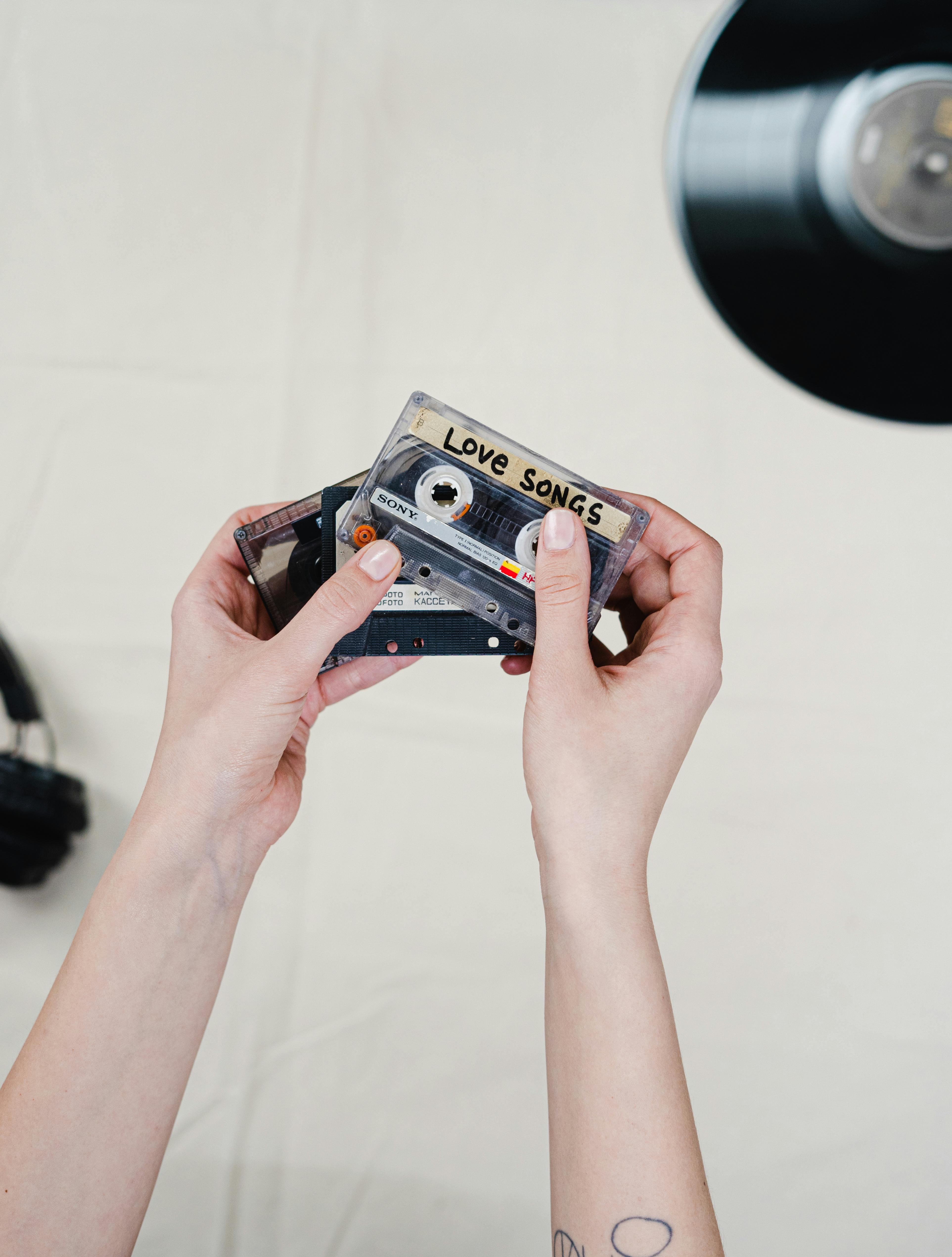 person holding blue and black cassette tape