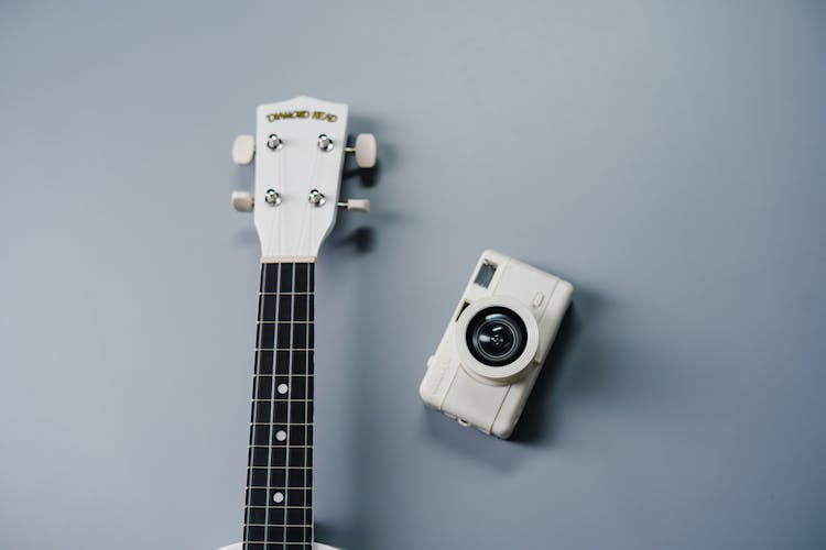 White And Black Camera On White Guitar