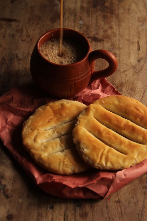 Free Cozy imagery of steaming coffee in a mug and flatbread on a wooden table. Stock Photo