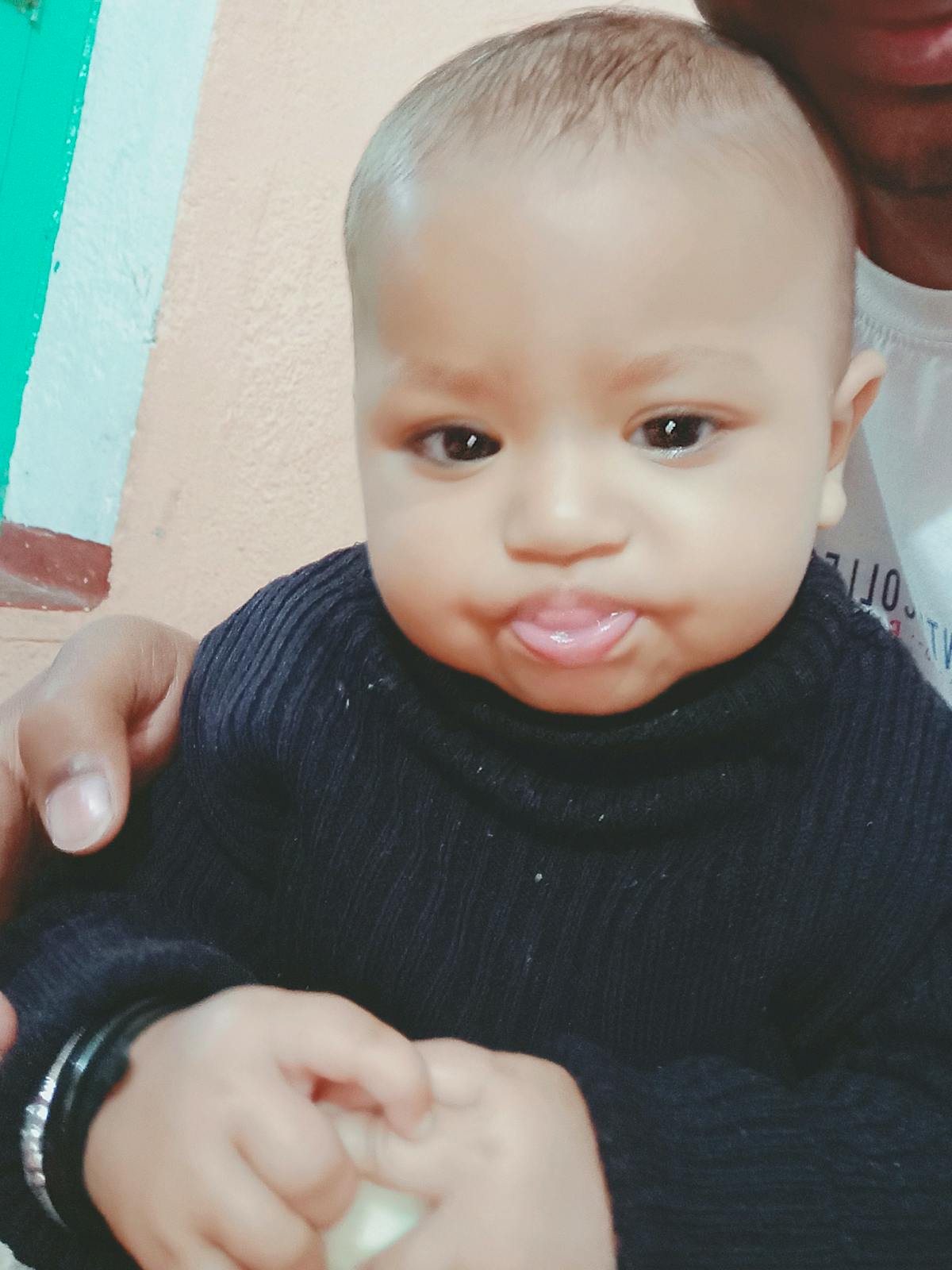 Person holding a remote control pointed at a TV showing a talk show