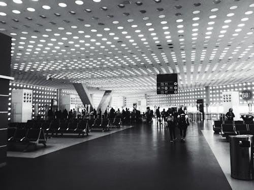 Free Grayscale Photography of People Walking on Concrete Pavement Hallway Stock Photo