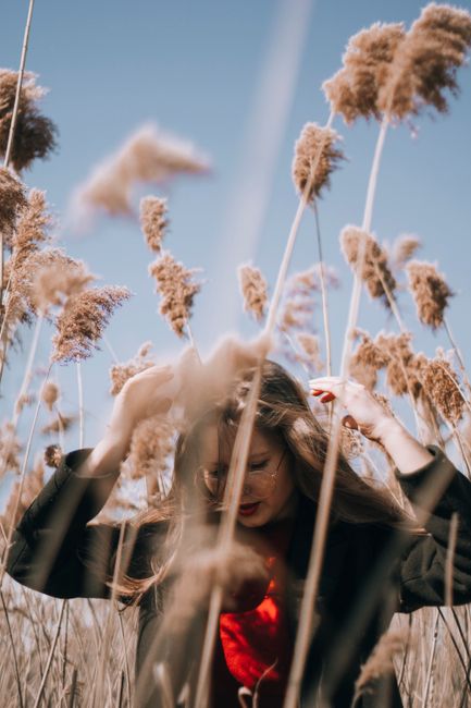 Young woman enjoys tranquility in a wheat field, embracing nature.