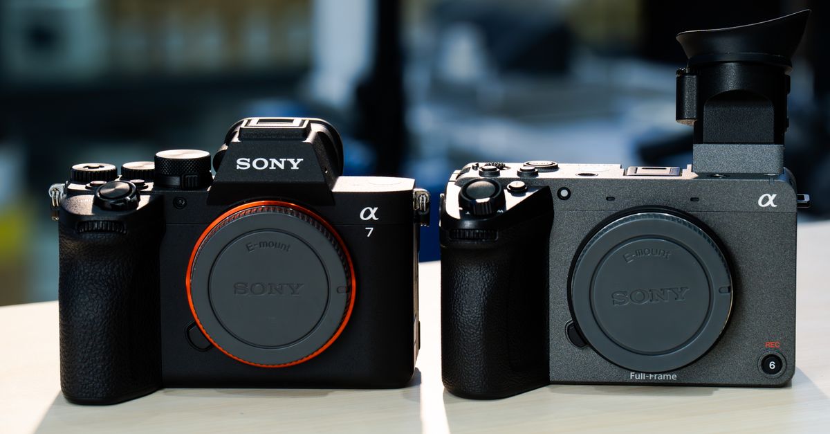 Side-by-side comparison of two modern mirrorless cameras on a table.