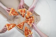 Photo Of People Holding Pizza