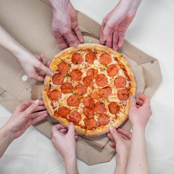 A group of friends enjoying a pepperoni pizza, sharing a fun meal together.