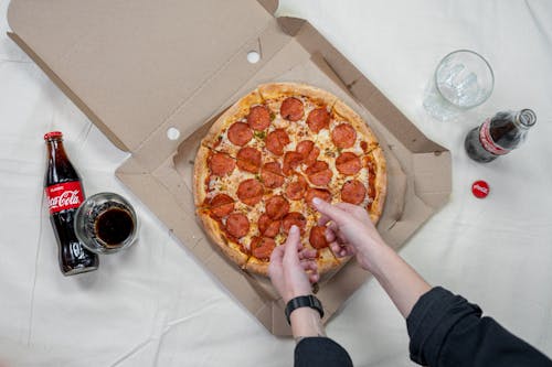 Person Holding Pizza With Cheese