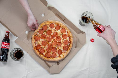 Person Holding Pizza on Box