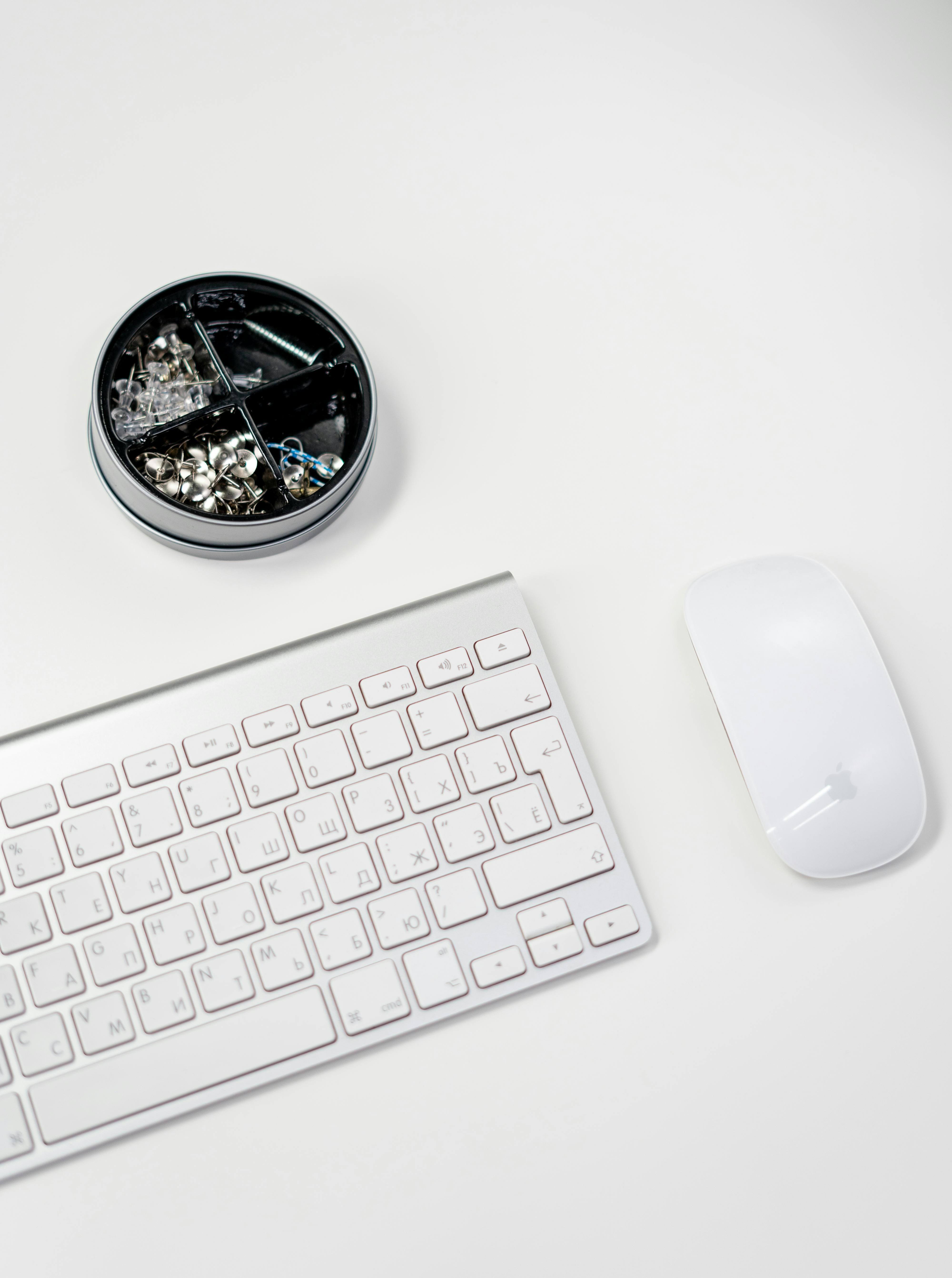 apple magic keyboard beside silver round analog watch