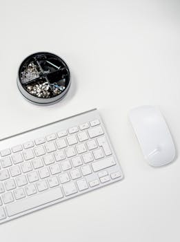 A clean and organized home office desk setup with an Apple keyboard and mouse.