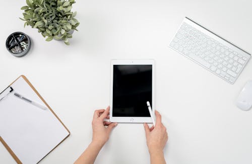 Free Person Holding White Ipad With Apple Keyboard Stock Photo