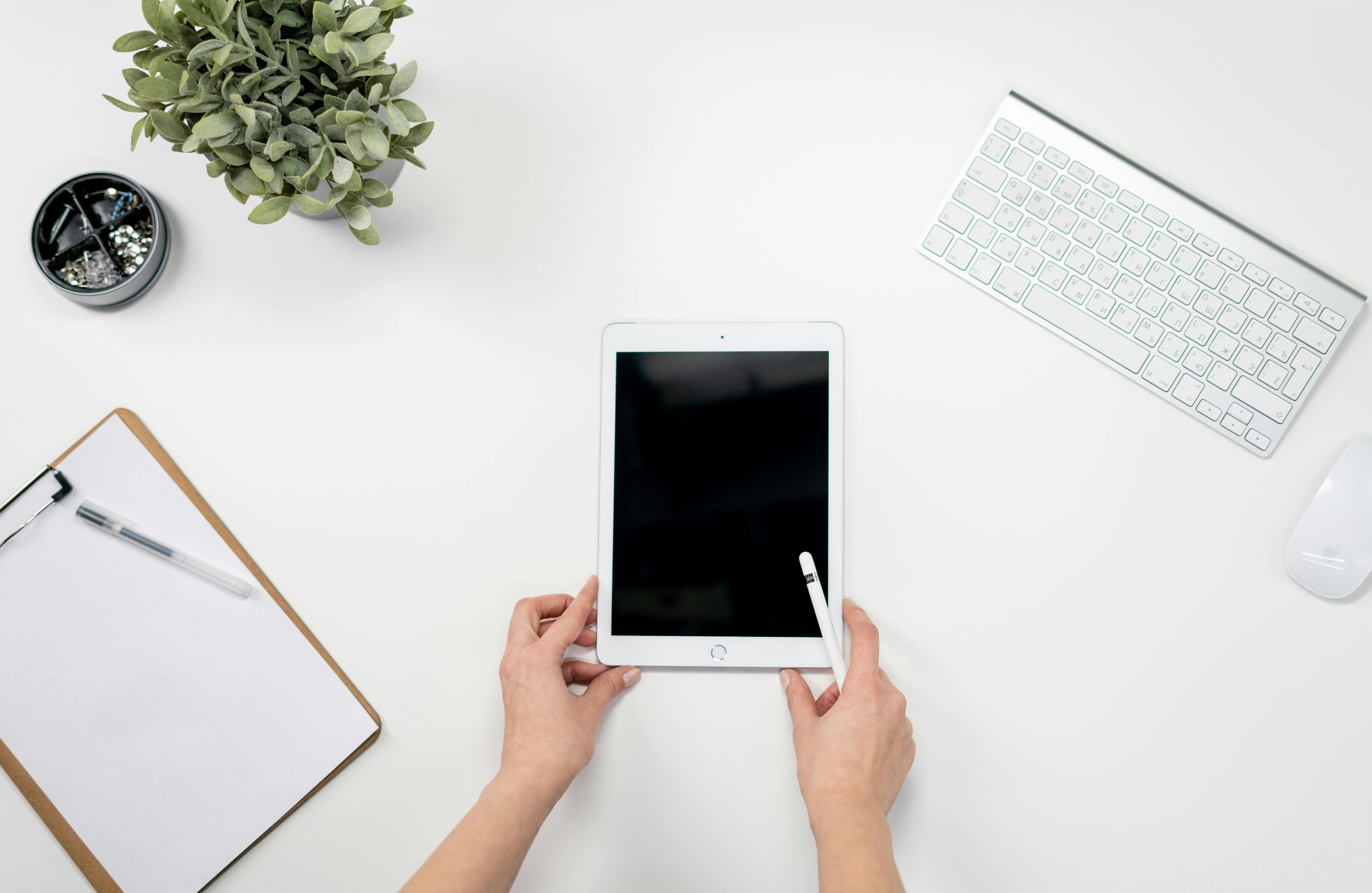 Person Holding White Ipad With Apple Keyboard · Free Stock Photo