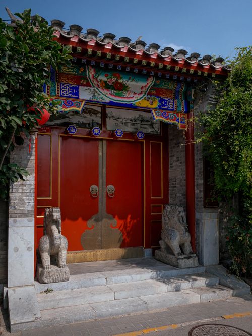 Free Vibrant traditional Chinese door with intricate details and stone lion statues, symbolizing protection. Stock Photo