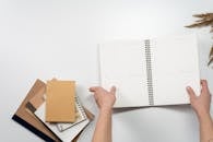 笔记本采用扁平布局，配有极简主义办公用品和植物元素