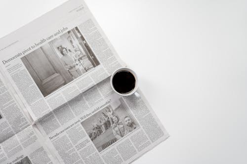White Ceramic Mug On Top of a Newspaper
