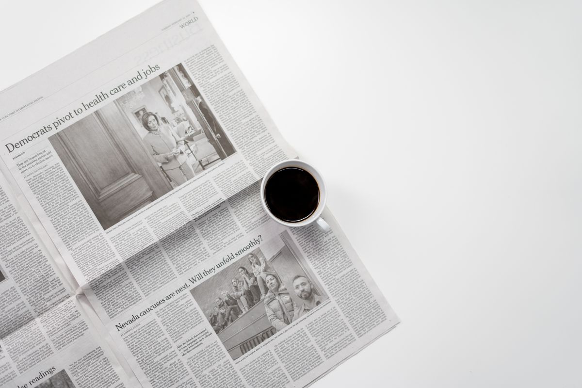 Fresh cup of coffee resting on a newspaper