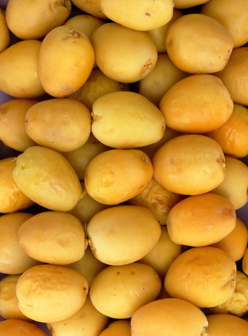 Free High-resolution close-up of fresh yellow dates, ideal for food and agricultural themes. Stock Photo