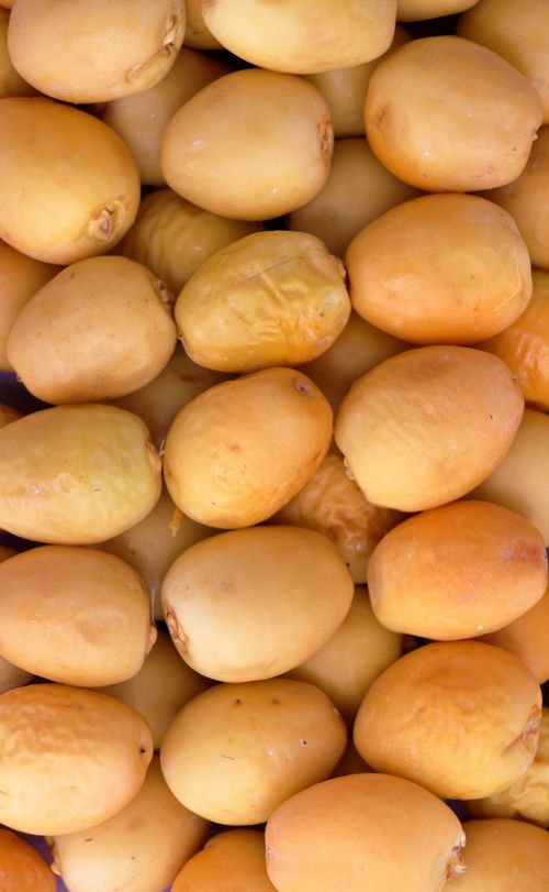Free High-quality close-up of fresh yellow dates, ideal for food and nutrition topics. Stock Photo