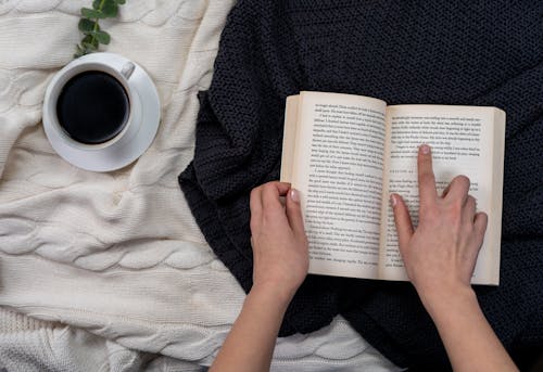Free Person in Black Sweater Holding Book Stock Photo