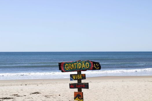 Vibrant sign with 'Gratidão' on a serene Paraná beach, Brasil.