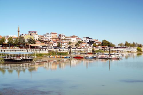 Free Tranquil scene of boats and town on the shores of Eğirdir Lake, Isparta, Türkiye. Stock Photo