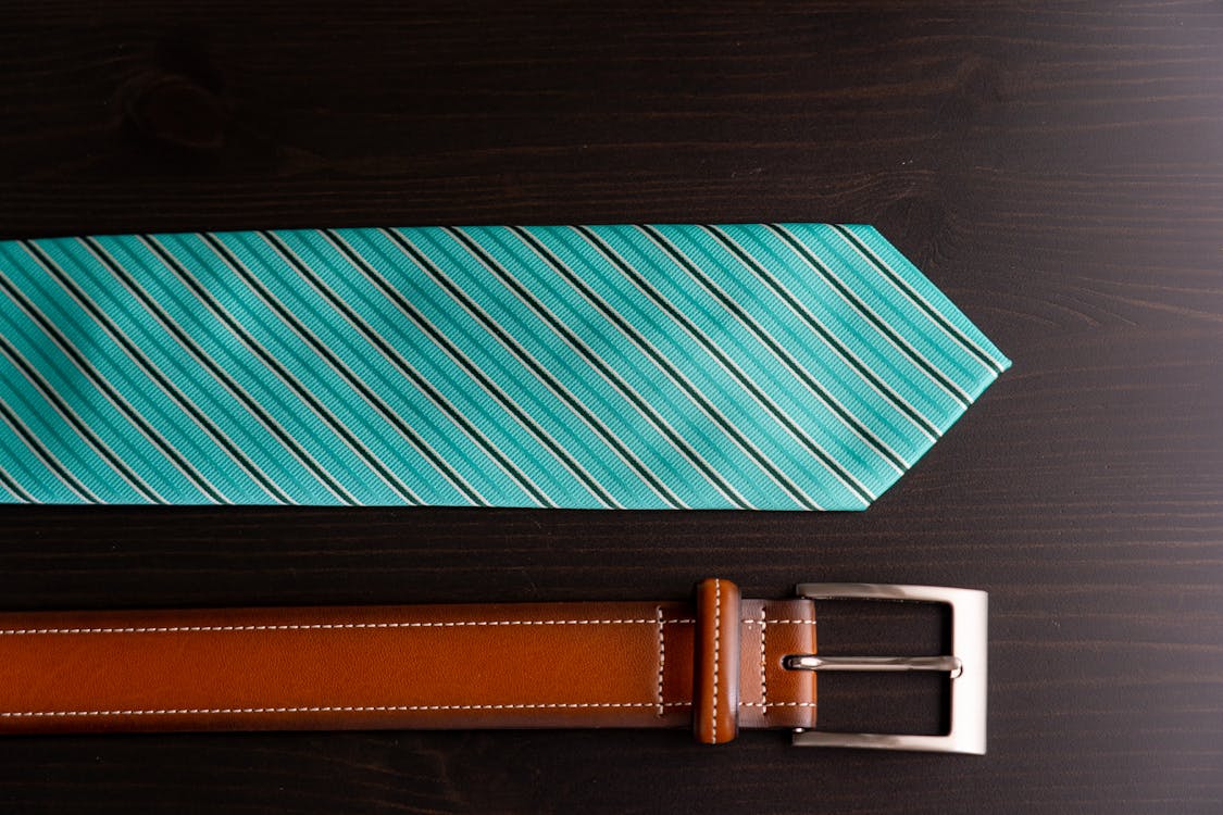 Free Striped Necktie Beside Leather Belt Stock Photo