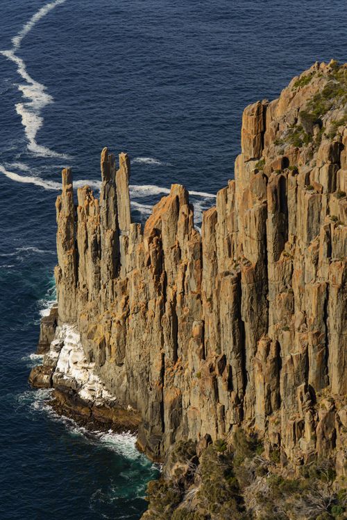 Free Stunning vertical cliffs with rich textures at Cape Raoul set against the blue ocean. Stock Photo
