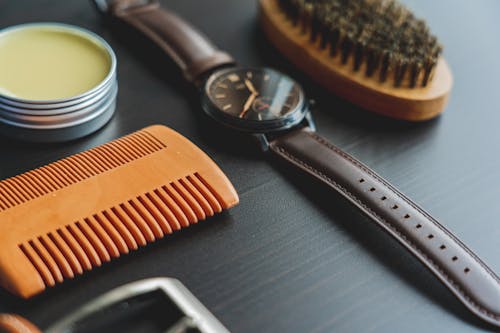 Analog Watch Beside A Comb