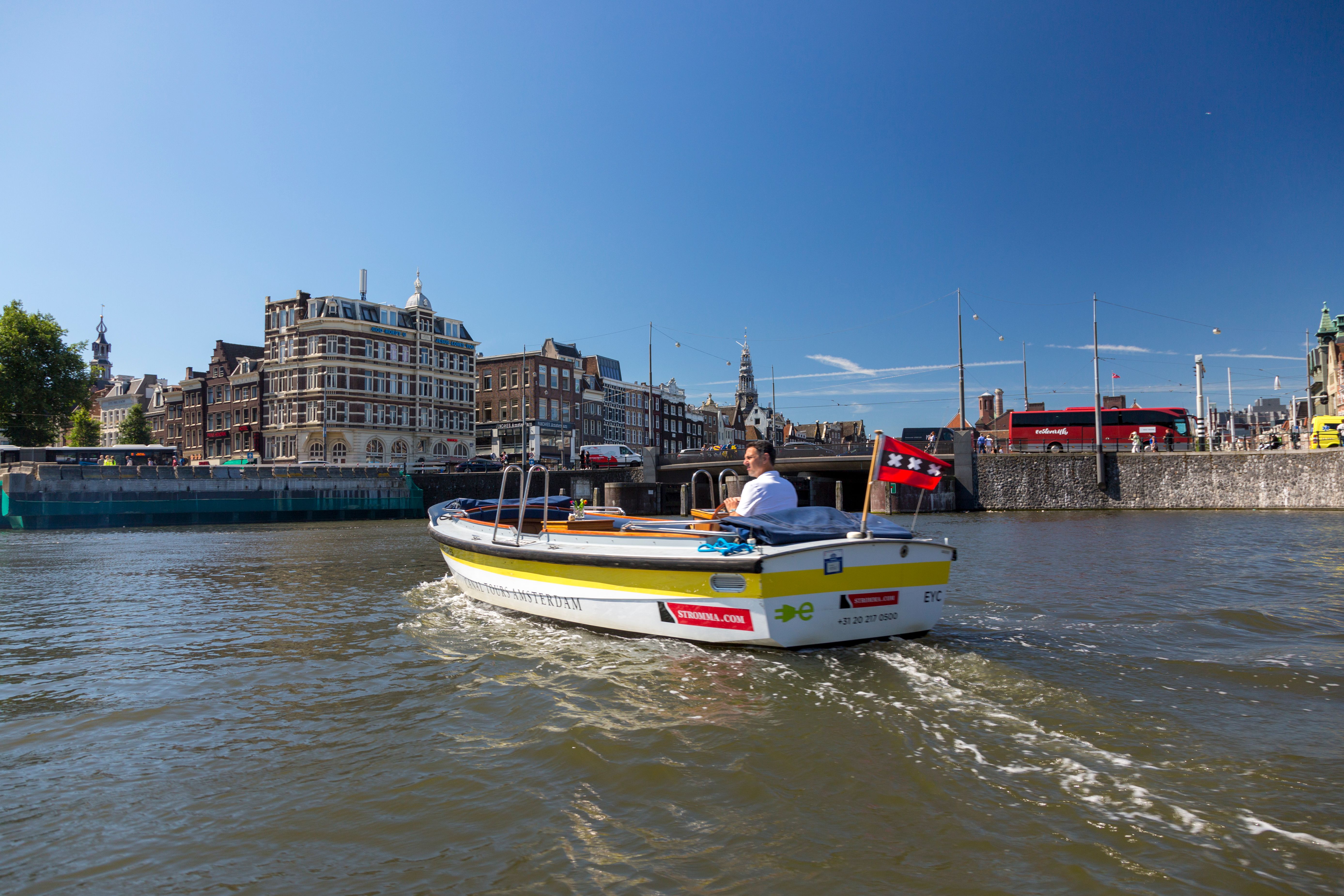 Boat cruising through Amsterdam's canals past historic architecture.