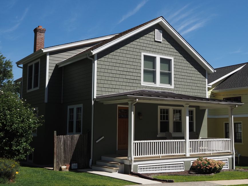 A quaint suburban home with a front porch under a clear sky in Doylestown, PA.
