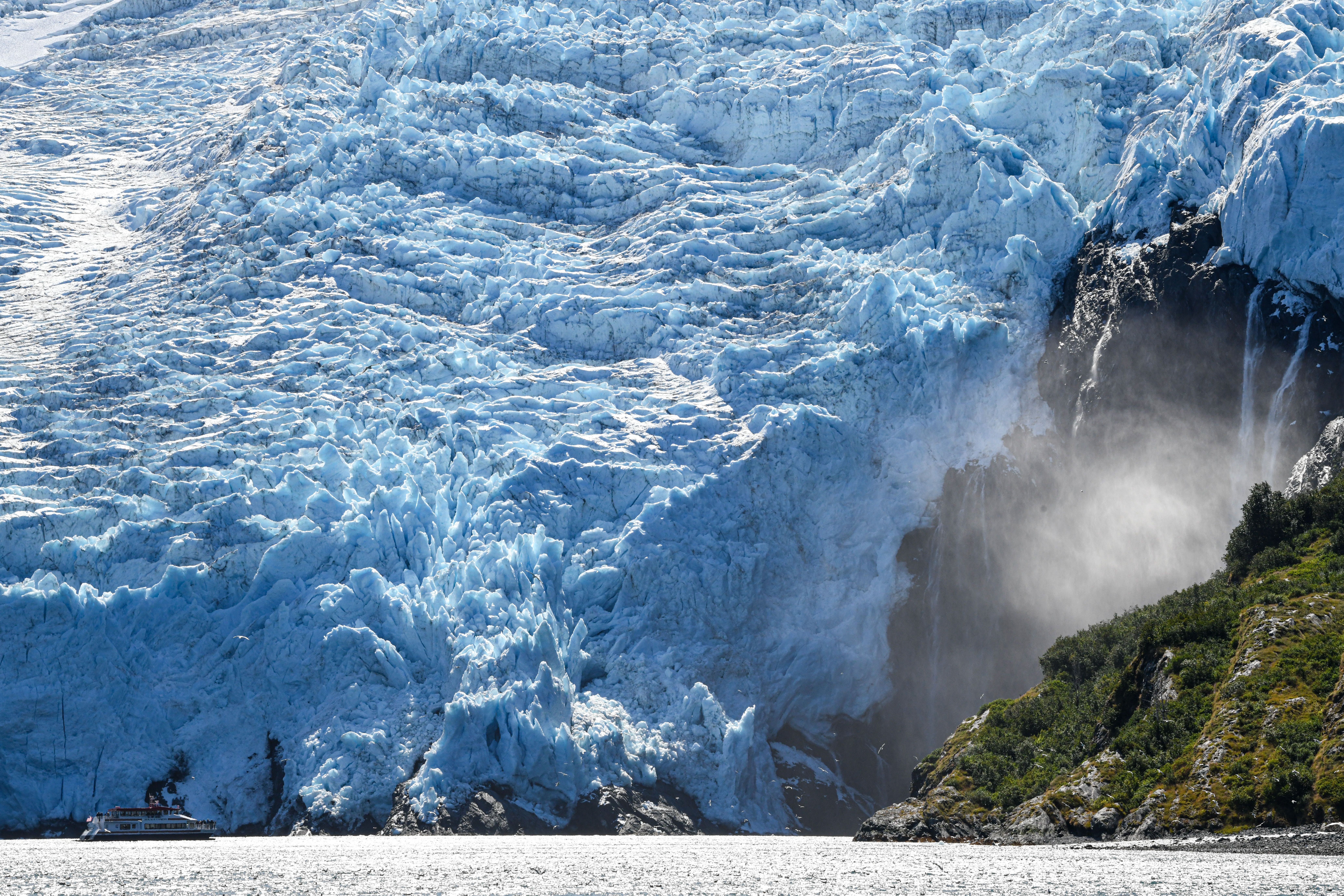 Dramatic view of Blackstone Glacier cascading into Prince William Sound, Alaska, under bright daylight.