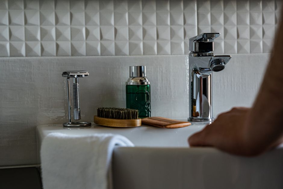 Grooming tools and products arranged around a bathroom sink