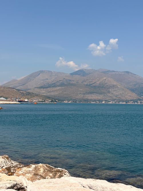 Free Experience the tranquil beauty of Formia's coastline with scenic mountains in the background, captured on a clear summer day. Stock Photo
