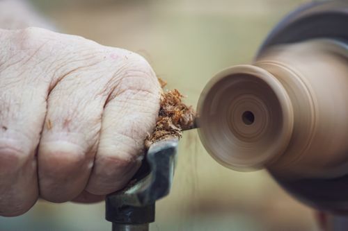 Free Hand carving wood on a lathe, showcasing precision and craftsmanship in woodworking. Stock Photo