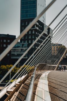 Dynamic view of a modern bridge and skyline in Bilbao, Spain, emphasizing architecture and urban design.