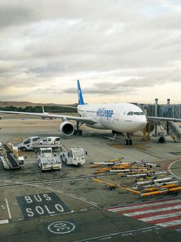 Air Europa Airbus A330-200 parked at airport terminal with support vehicles.