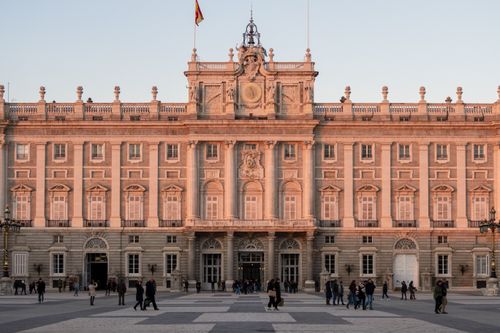 Free The magnificent facade of the Royal Palace of Madrid captured at sunset with subtle warm tones. Stock Photo
