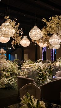Luxurious indoor wedding setting with chandeliers and floral arrangements.